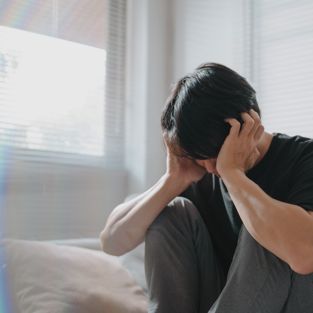 a student covering his face with his hands in distress